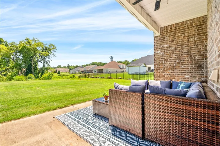 Relax on this covered patio, overlooking a spacious, well-maintained lawn.