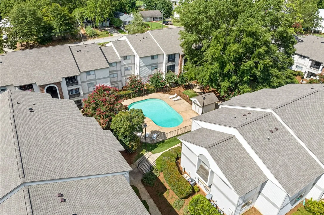 An aerial perspective reveals a sparkling community pool nestled amongst well-maintained townhomes.