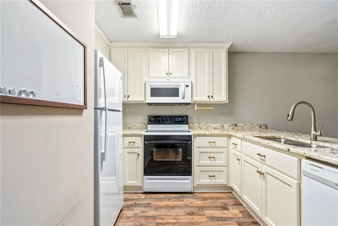 A well-appointed kitchen features ample cabinetry, granite counters, and modern appliances.