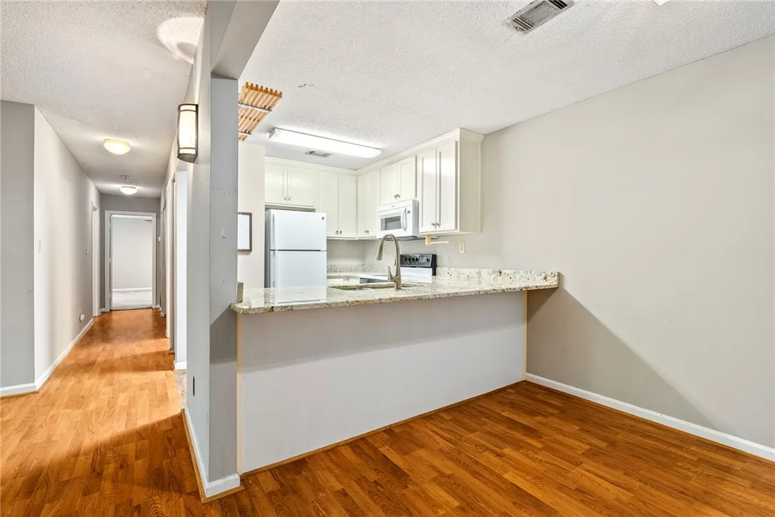 A compact kitchen with sleek appliances and granite countertops offers efficient culinary space.