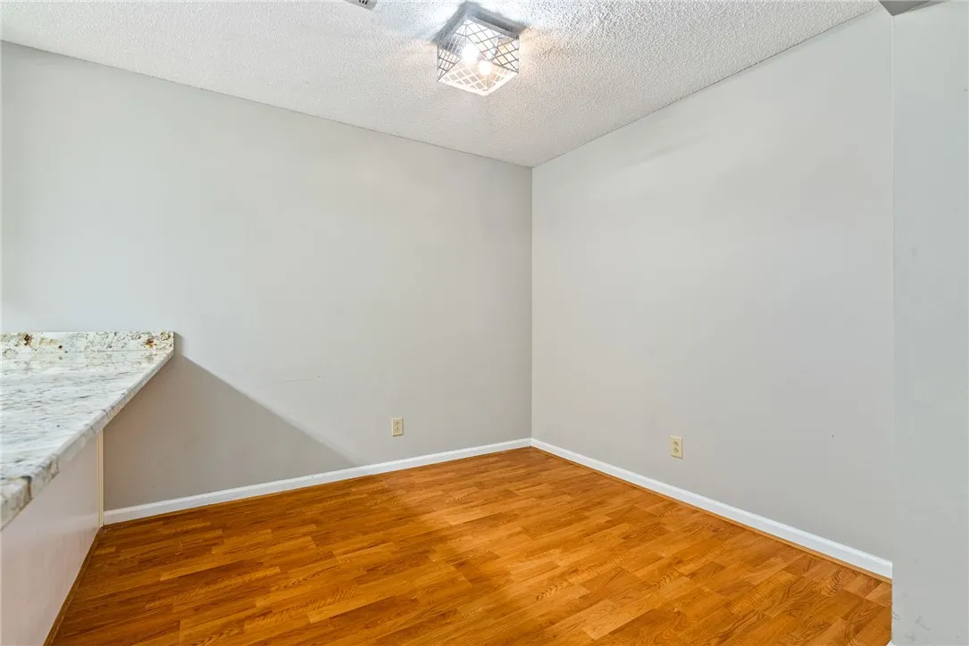 Bright breakfast nook features warm hardwood flooring and granite countertop space, ready for your custom touches.