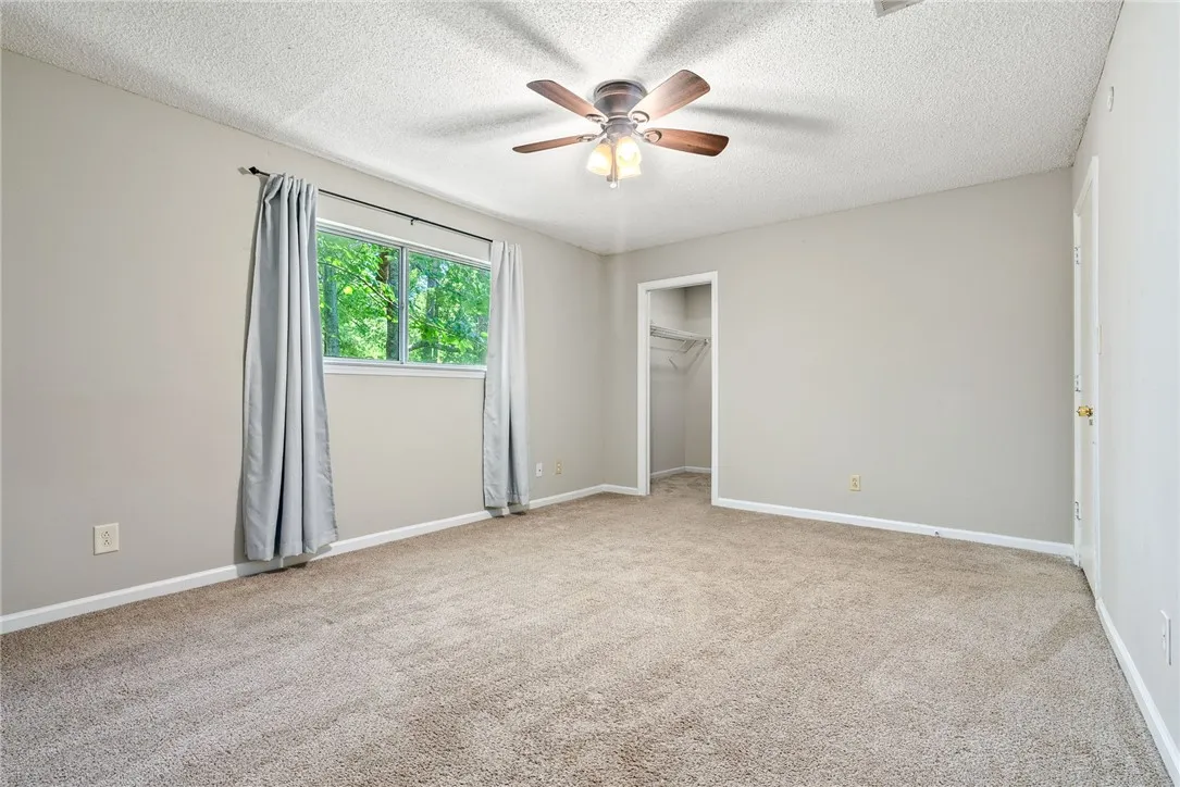 A quiet bedroom offers plush carpeting and a convenient closet, ideal for tranquil living.