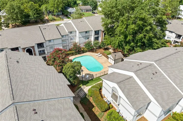An aerial perspective reveals a sparkling community pool nestled amongst well-maintained townhomes.
