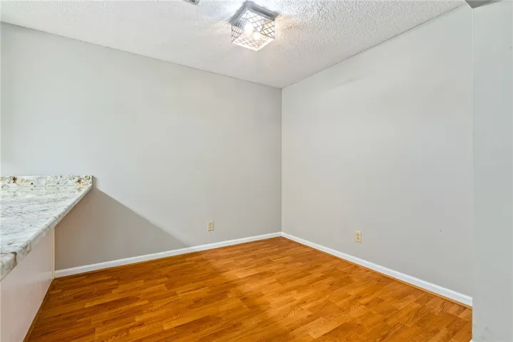 Bright breakfast nook features warm hardwood flooring and granite countertop space, ready for your custom touches.