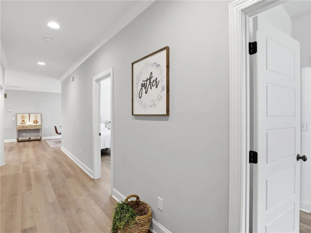 Elegant crown molding complements natural wood flooring, creating a polished pathway throughout the interior.