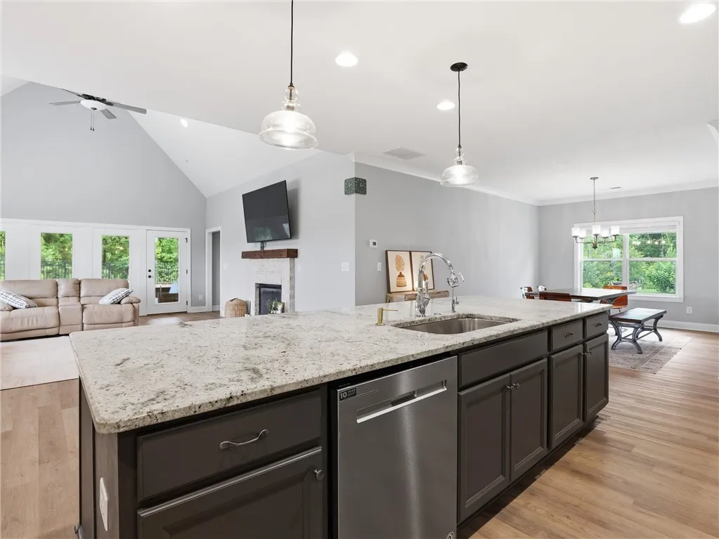 An open concept living area boasts a kitchen island with sink and a spacious area for entertaining.