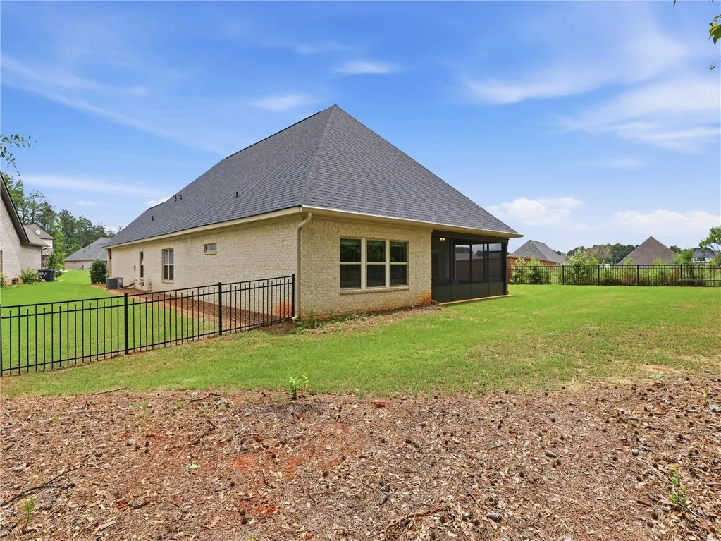 A well-maintained brick exterior with a screened porch complements the generous yard space.