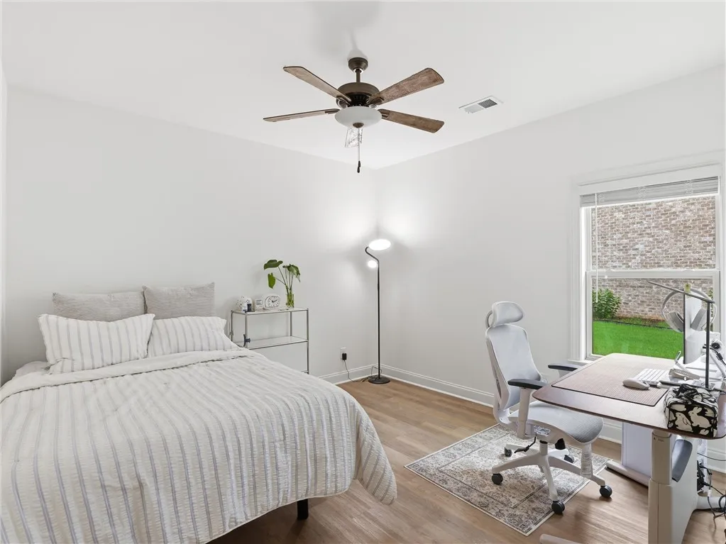 Well-lit room with wood flooring and a refreshing view of the outdoors.