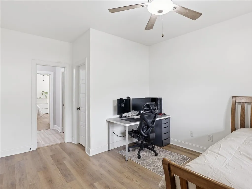 A versatile room with durable laminate flooring and a ceiling fan, perfect for a home office or extra bedroom.