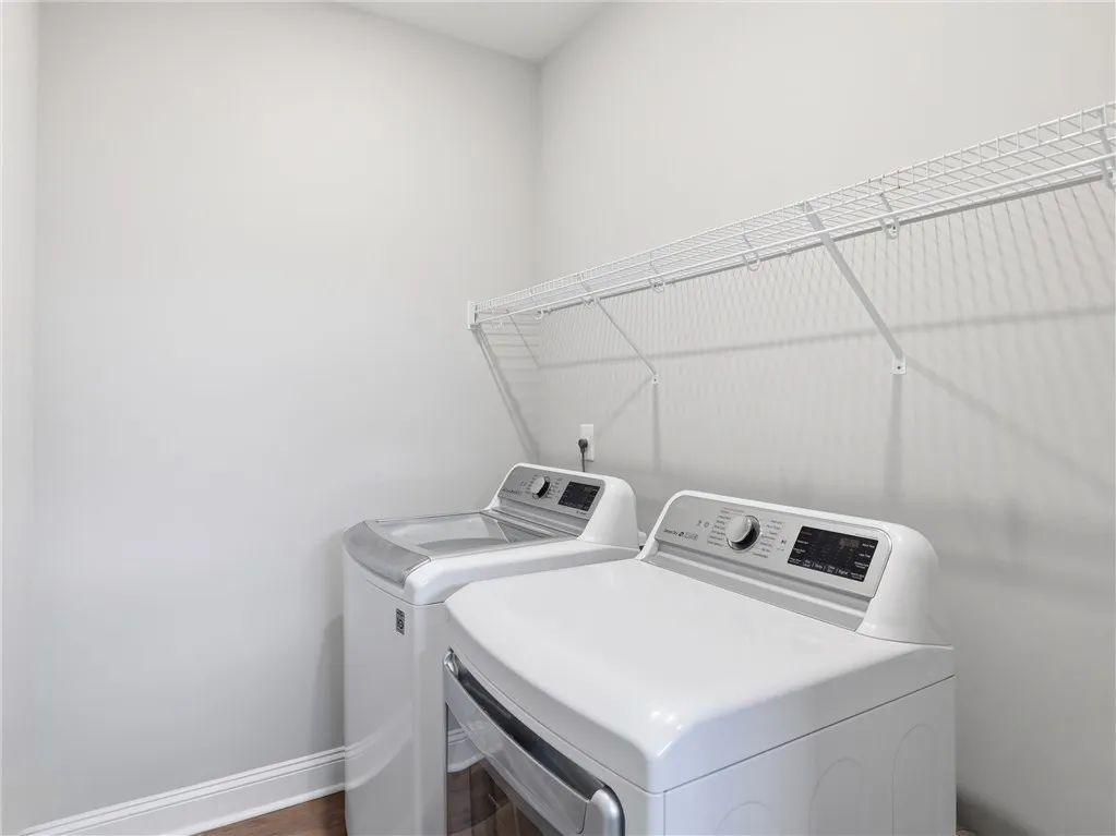 Functional laundry room equipped with modern appliances and convenient shelving.