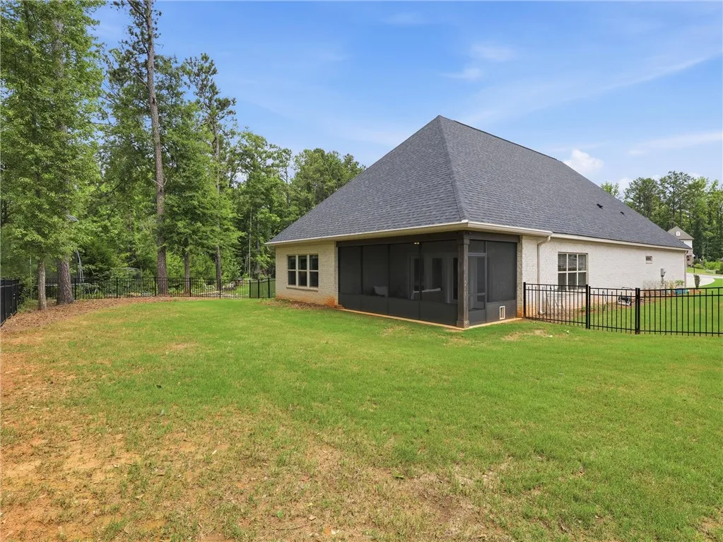 A well-maintained lawn with a screened-in porch offers tranquil outdoor living.