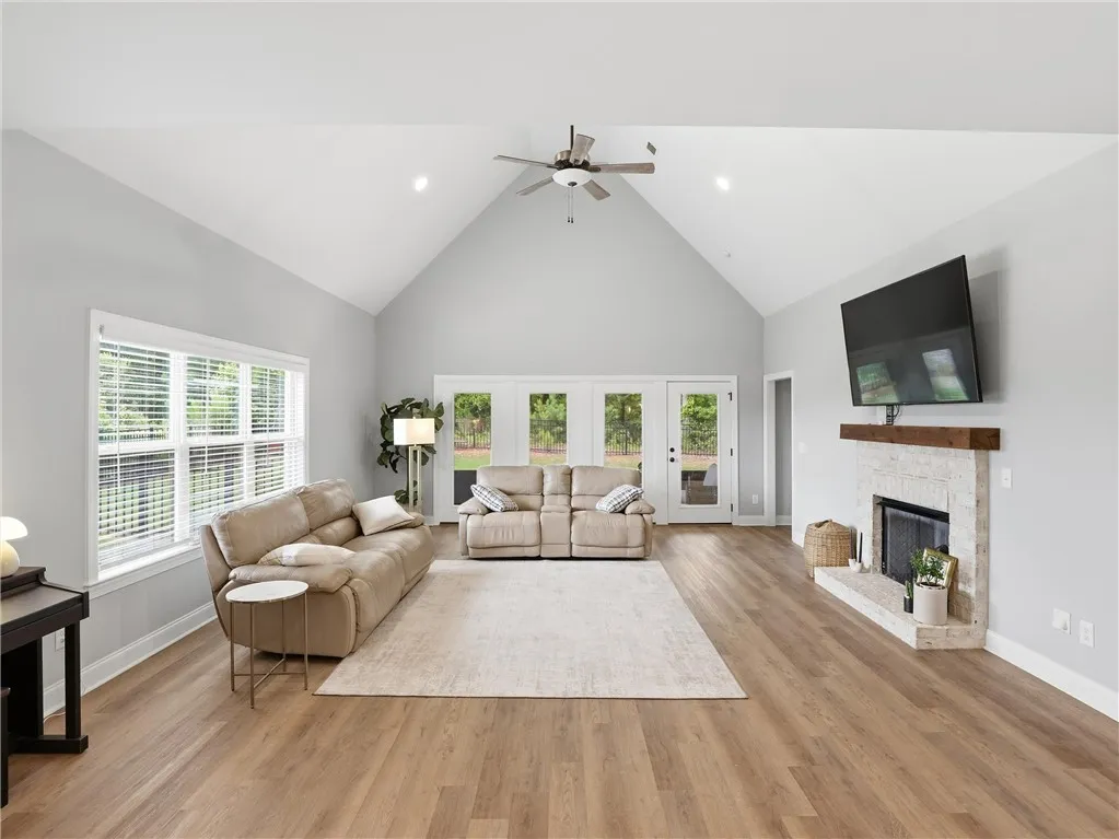 A spacious living room welcomes with soaring vaulted ceilings and rich wood flooring.