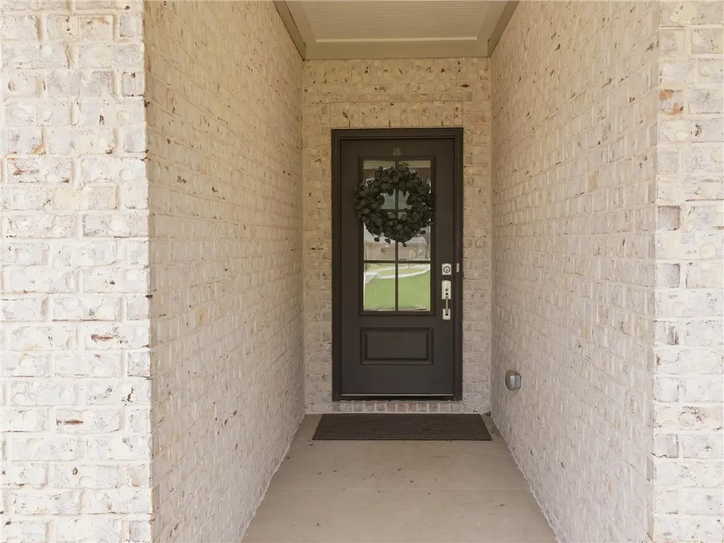 A welcoming front entry features light-colored brick and a classic dark door.