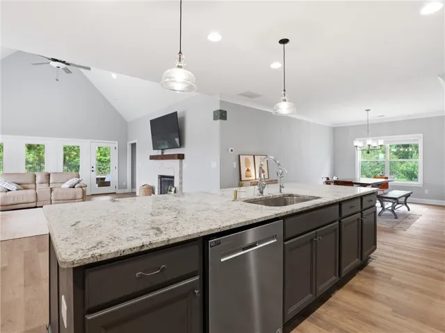An open concept living area boasts a kitchen island with sink and a spacious area for entertaining.