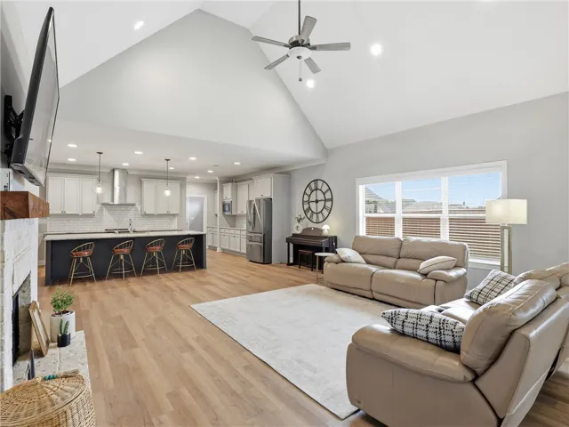 A vaulted ceiling living area connects seamlessly with a modern kitchen, creating an inviting gathering space.