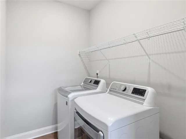 Functional laundry room equipped with modern appliances and convenient shelving.
