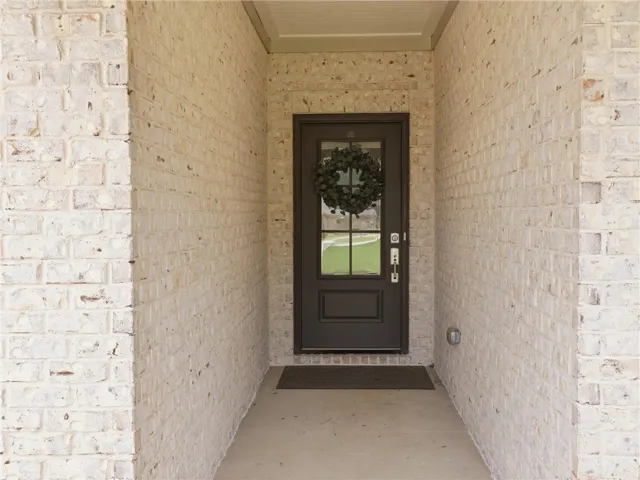 A welcoming front entry features light-colored brick and a classic dark door.