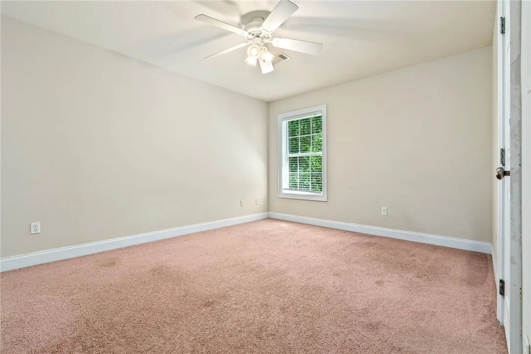 Well-lit and ready for personalization, this room features a generous window overlooking lush greenery.