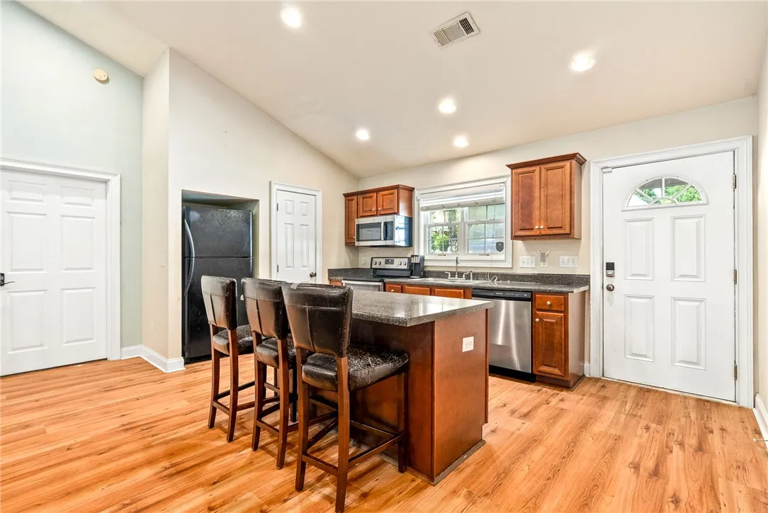 A cheerful kitchen awaits, complete with a functional island and warm wood-toned cabinetry.