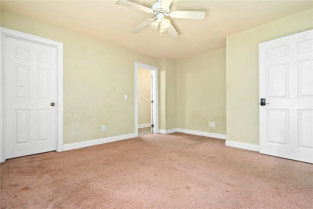 Functional bedroom featuring a ceiling fan and convenient doorways to adjacent spaces.
