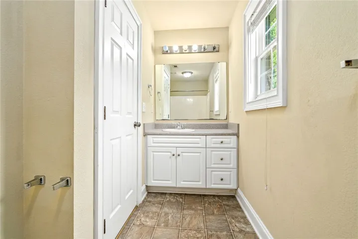 Well-lit bathroom with a bright window and a practical vanity setup.