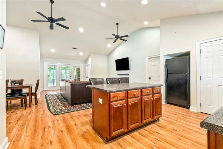 An inviting open-concept living space features vaulted ceilings and French doors leading to outdoor leisure.