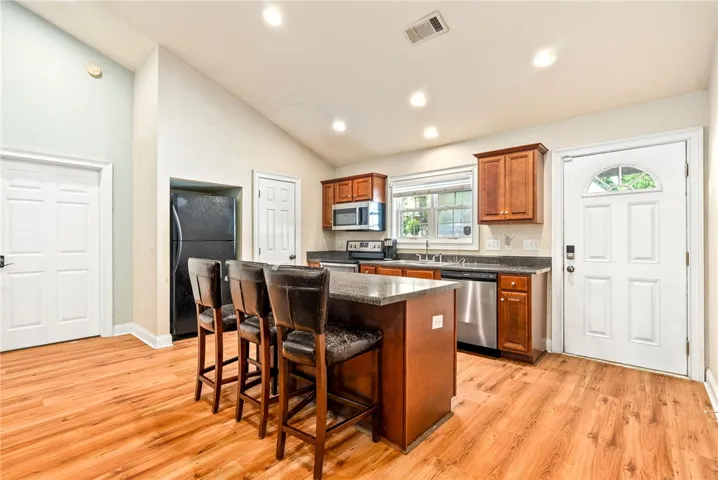 A cheerful kitchen awaits, complete with a functional island and warm wood-toned cabinetry.