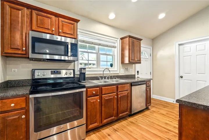 A well-appointed kitchen showcasing durable wood flooring and ample cabinetry.