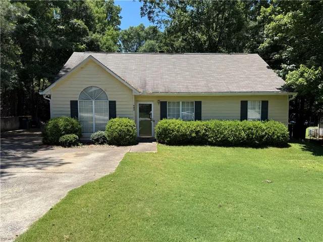 A classic ranch home nestled among mature trees offers serene suburban living.
