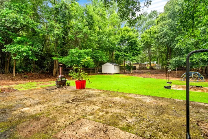 A spacious yard with mature trees and a detached shed provides ample outdoor living.