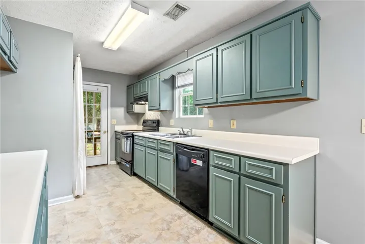 A well-appointed kitchen featuring ample cabinetry and direct outdoor access.