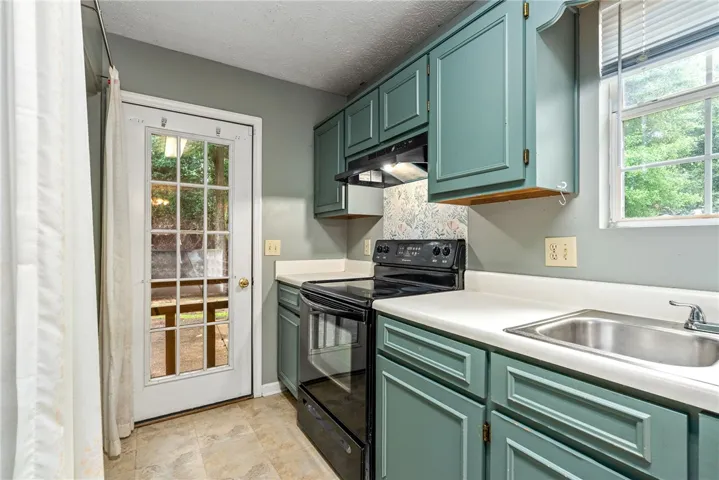 A well-appointed kitchen features a practical layout and seamless access to the outdoors.