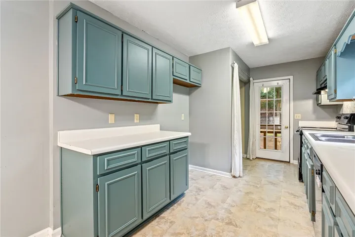 Functional kitchen offers ample cabinetry and counter space, with convenient outdoor access.