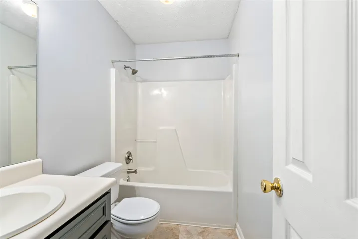 A well-maintained bathroom with a convenient tub and shower combination and functional vanity.