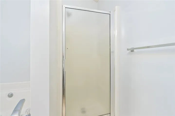 Streamlined shower stall offers modern utility in this well-appointed bath.
