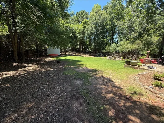 A spacious backyard retreat provides ample room for outdoor activities and serene moments amidst mature trees.