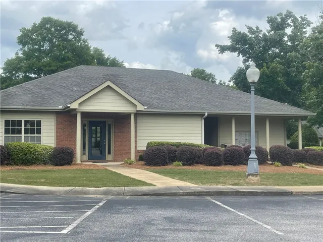 A welcoming front entrance features brick accents and a well-maintained landscape.