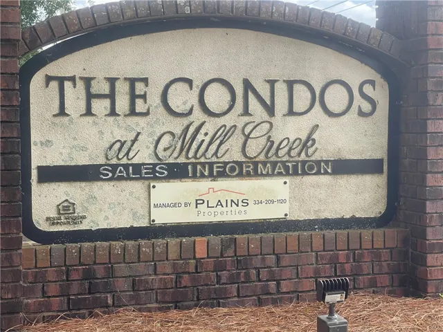 A welcoming brick and stucco monument sign marks the entry to the community.
