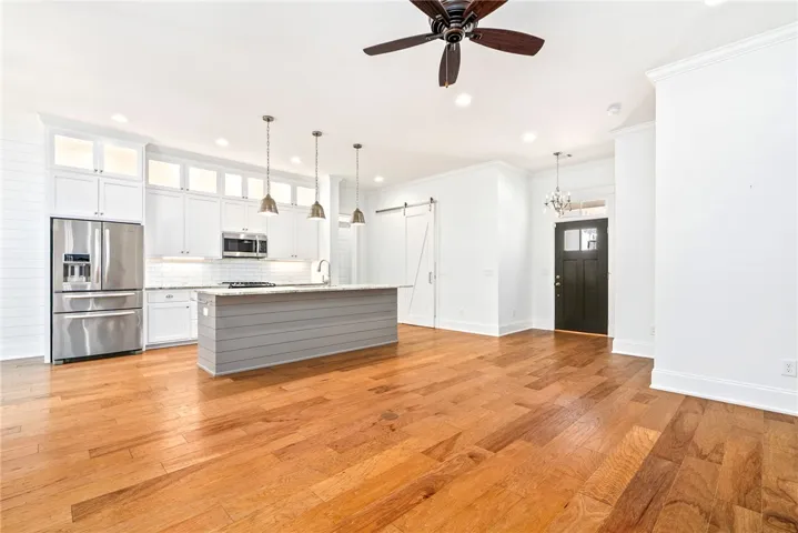 An open-concept living space highlights a well-appointed kitchen and rich hardwood flooring.