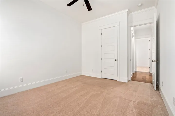 A well-lit room featuring plush carpeting and crisp white trim, awaiting your personal touch.
