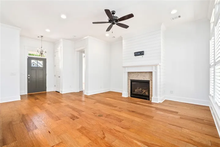 Bright hardwood flooring flows through this living space, featuring a cozy fireplace.