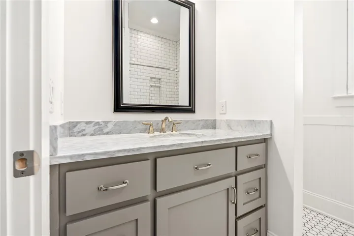Marble vanity and sleek cabinetry combine for a refined bathroom space.