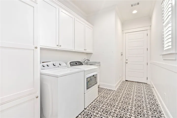 A well-appointed laundry room with functional appliances and chic patterned flooring.