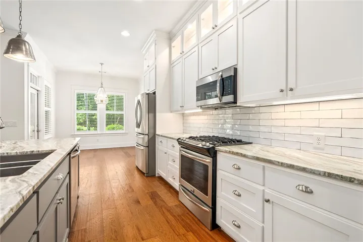 Culinary delights await in this bright kitchen with gleaming hardwood floors and ample counter space.