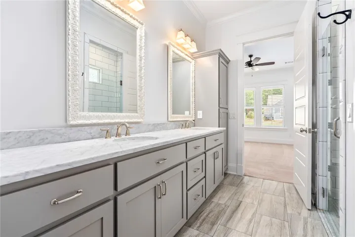 Double vanities with sleek cabinetry and natural light enhance this practical bathroom space.