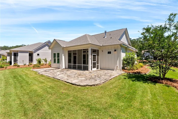 A well-maintained lawn embraces a secluded patio and a charming screened porch.