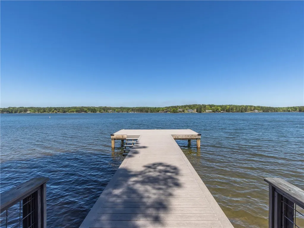 A private boat dock extends into the tranquil lake, offering serene water access and scenic views.