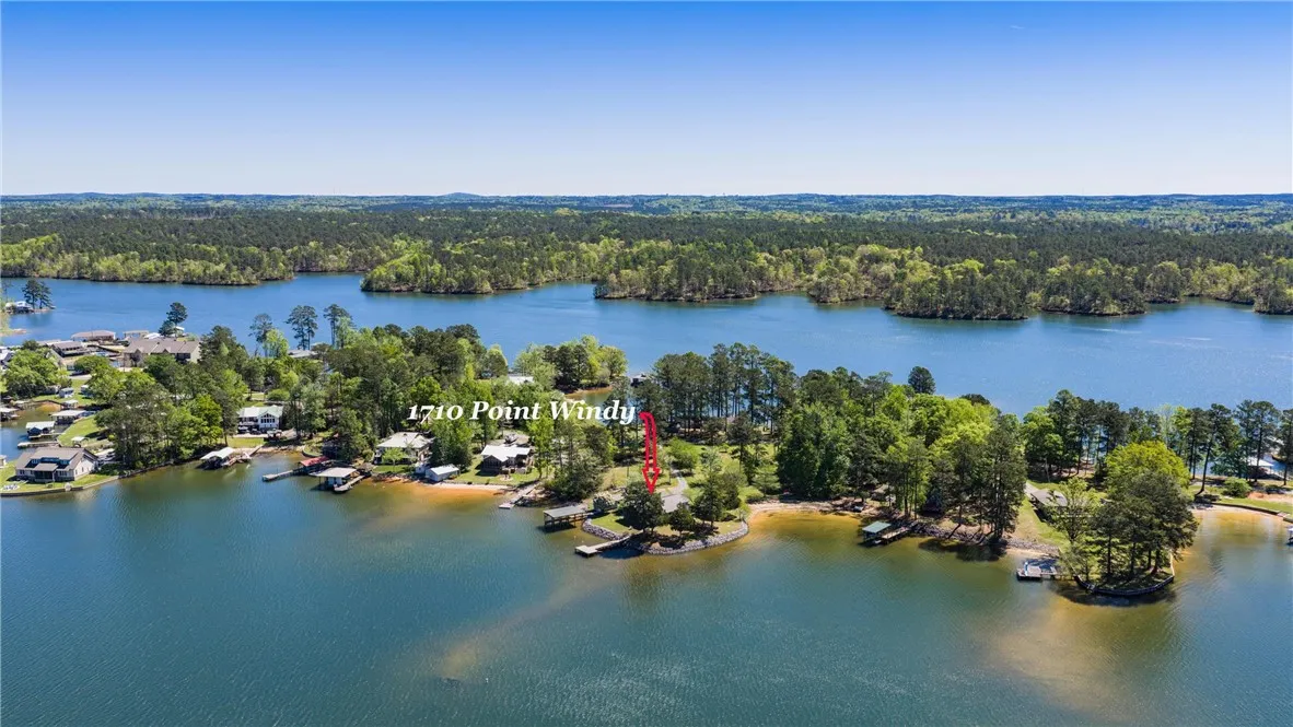 Discover a private waterfront sanctuary with this expansive lake view property, showcasing a pristine dock and lush natural surroundings.