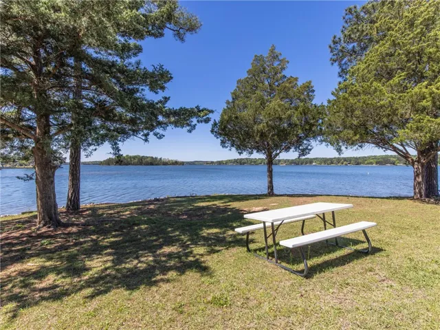 Relax riverside with panoramic lake views, shaded by mature trees.