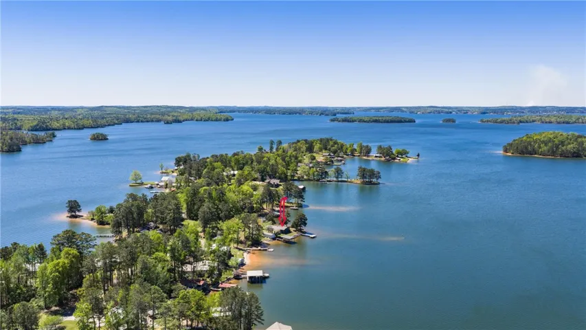 An aerial perspective reveals a serene lake dotted with verdant islands and surrounding wooded shores.